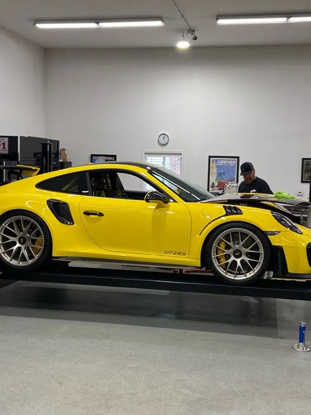 Yellow Porsche GT3 RS on the lift for paint protection film