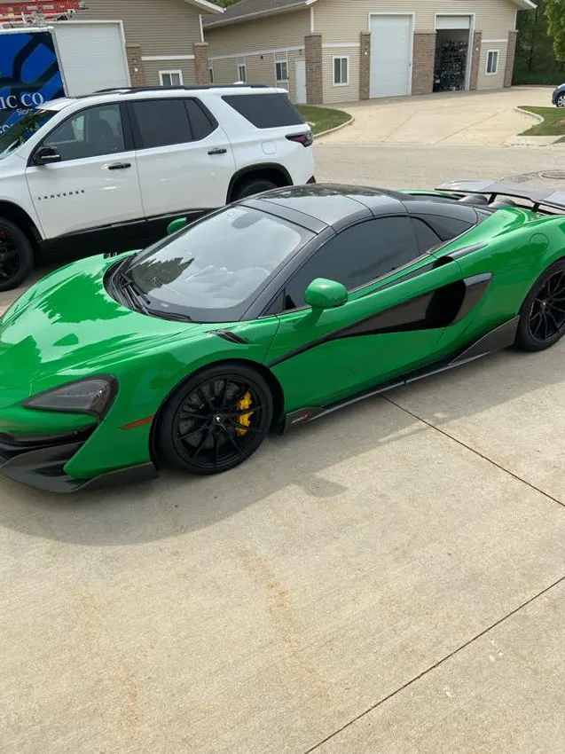 Green McLaren parked outside the shop