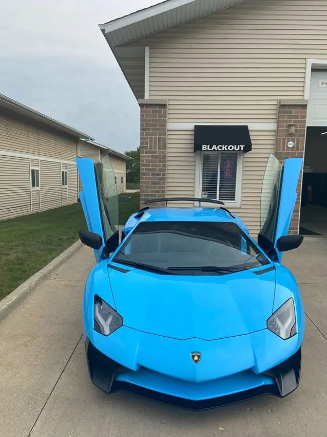 Lamborghini Aventador with doors up outside the shop