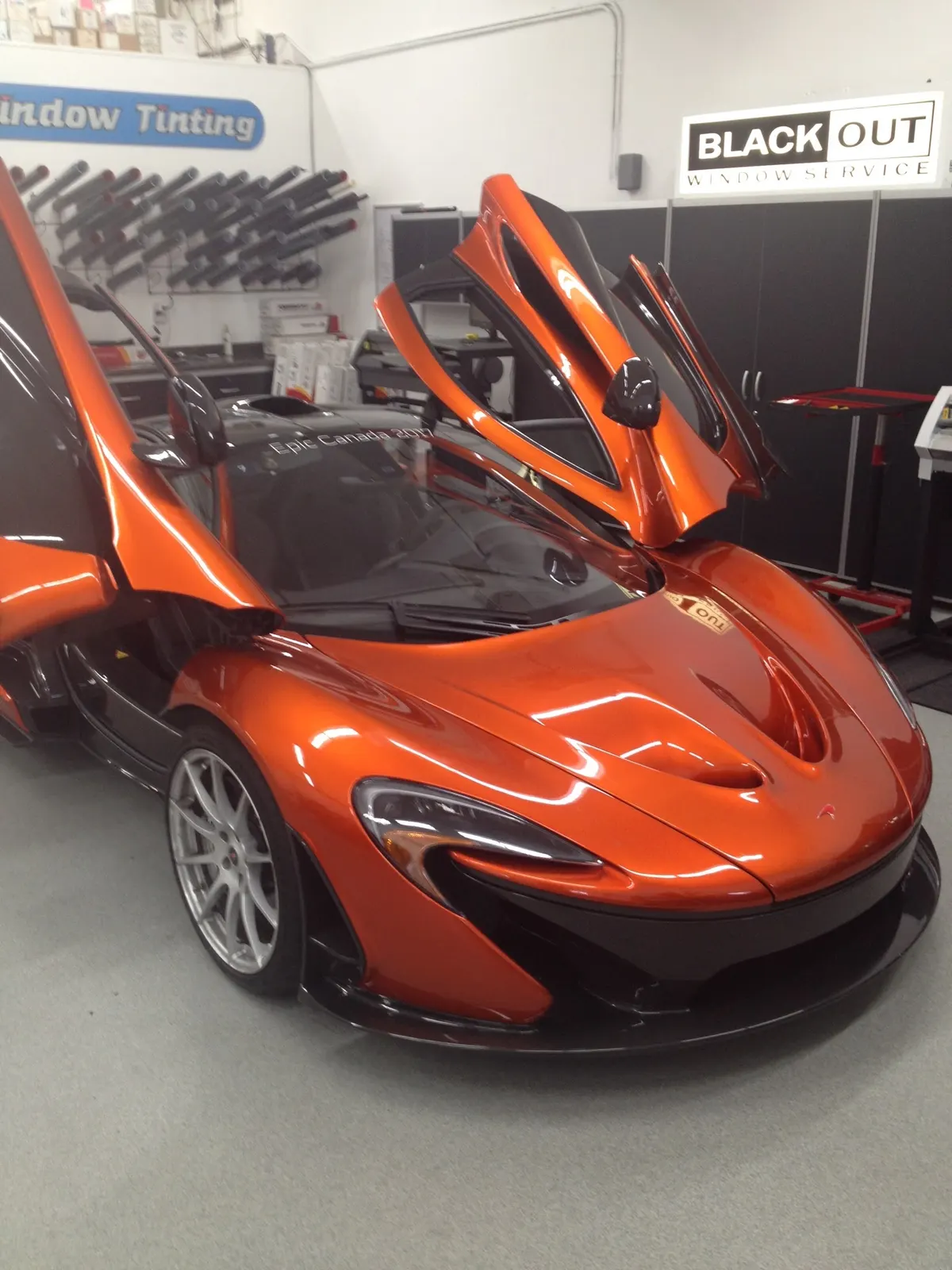 Orange McLaren with doors up inside the Blackout shop